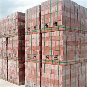 Green PET strapping is used to secure red clay bricks.